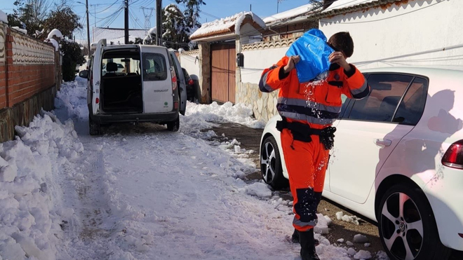 Un voluntario de Protección Civil esparce sal entre las calles de San Martín de la Vega.