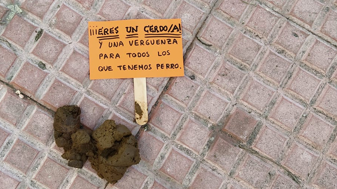 Uno de los carteles dirigidos a "los cerdos" sobre un excremento.