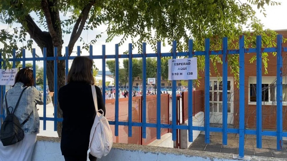 Dos madres esperan a sus hijos en la puerta del Colegio El Prado.