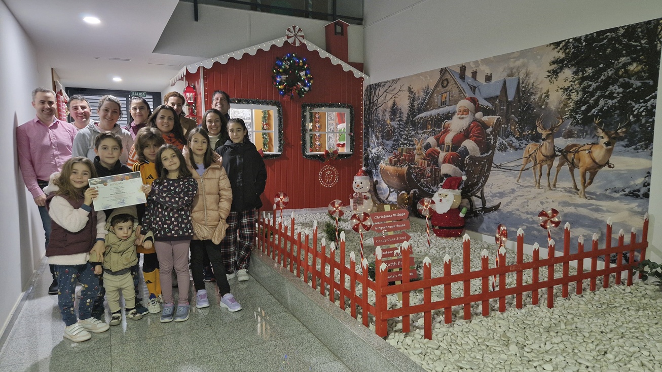 Los vecinos de Grand Tenería posan con el premio junto a la casa de Papá Noel.