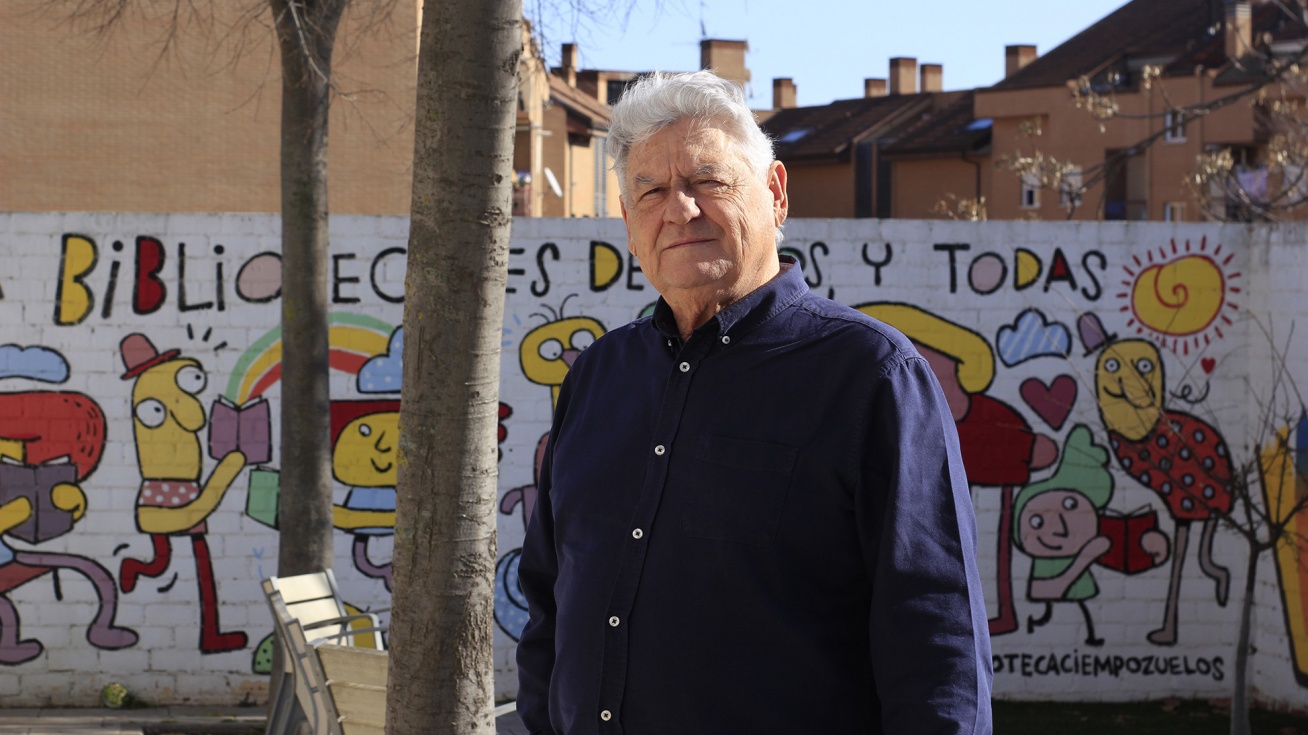 Santiago Gómez frente los murales de la Biblioteca Municipal Almudena Grandes.