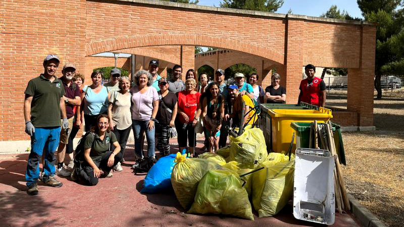 Grupo de vecinos en la recogida de basura del parque municipal.