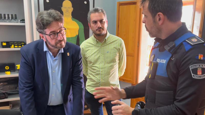 Un agente explica al alcalde y al concejal de Seguridad cómo funcionan las pistolas Taser.