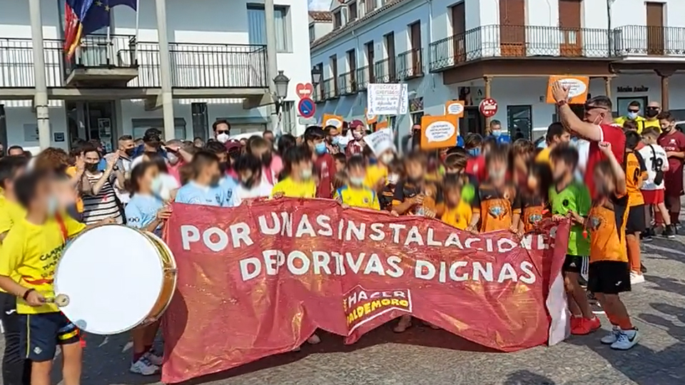 Niños portan la pancarta del grupo xenófobo Hacer Nación Valdemoro en la protesta de los clubes deportivos exigiendo unas instalaciones dignas.