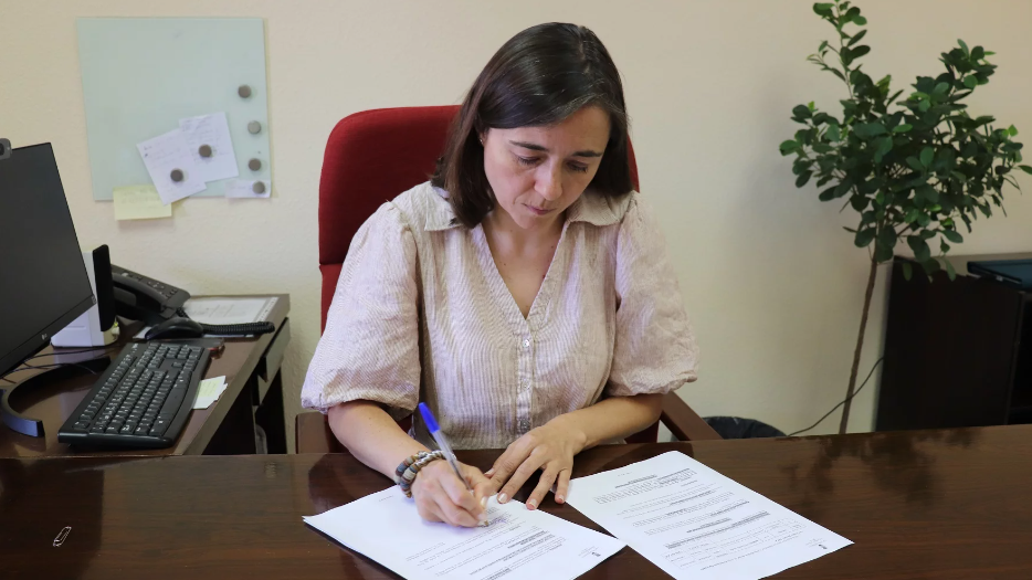 La primera edil, Raquel Jimeno, firmando un pago de la deuda económica.
