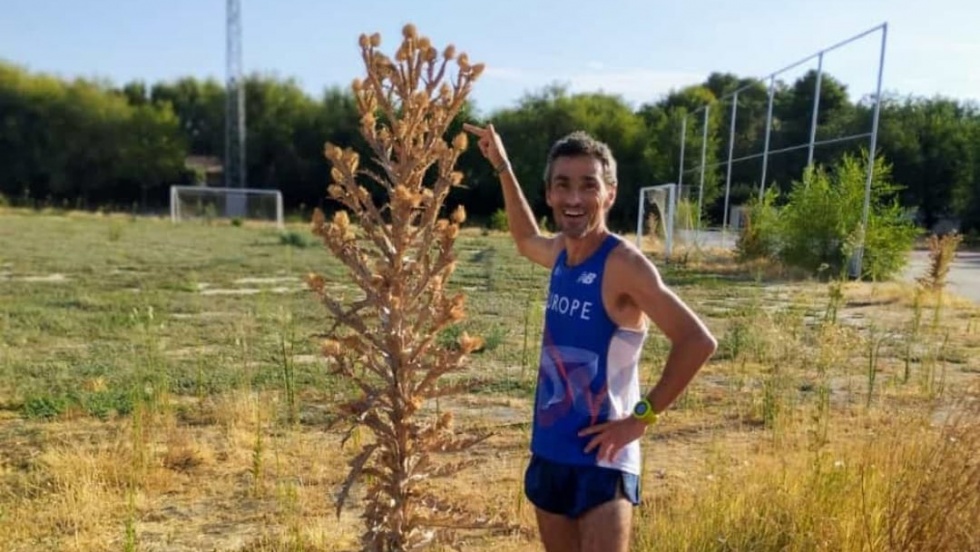 Jesús España posa junto a la vegetación de la pista de atletismo.