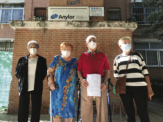 Los residentes del número trece Parque Éboli, posan junto a su licencia de ascensor.