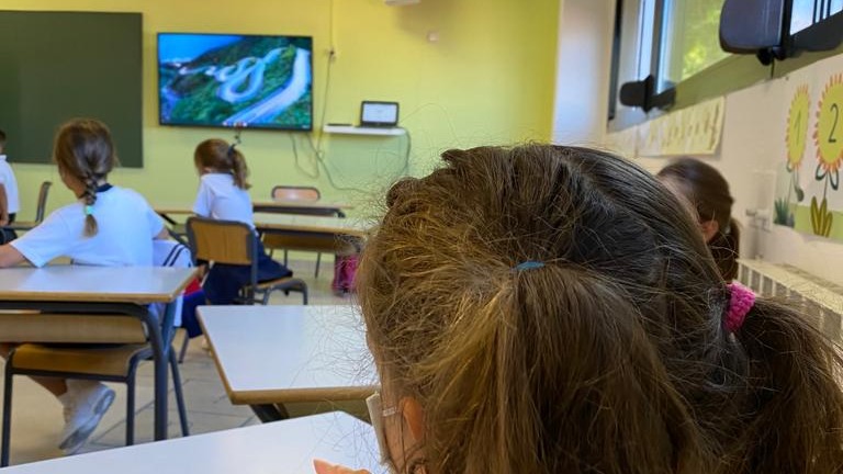 Una joven con mascarilla atiende durante una clase.