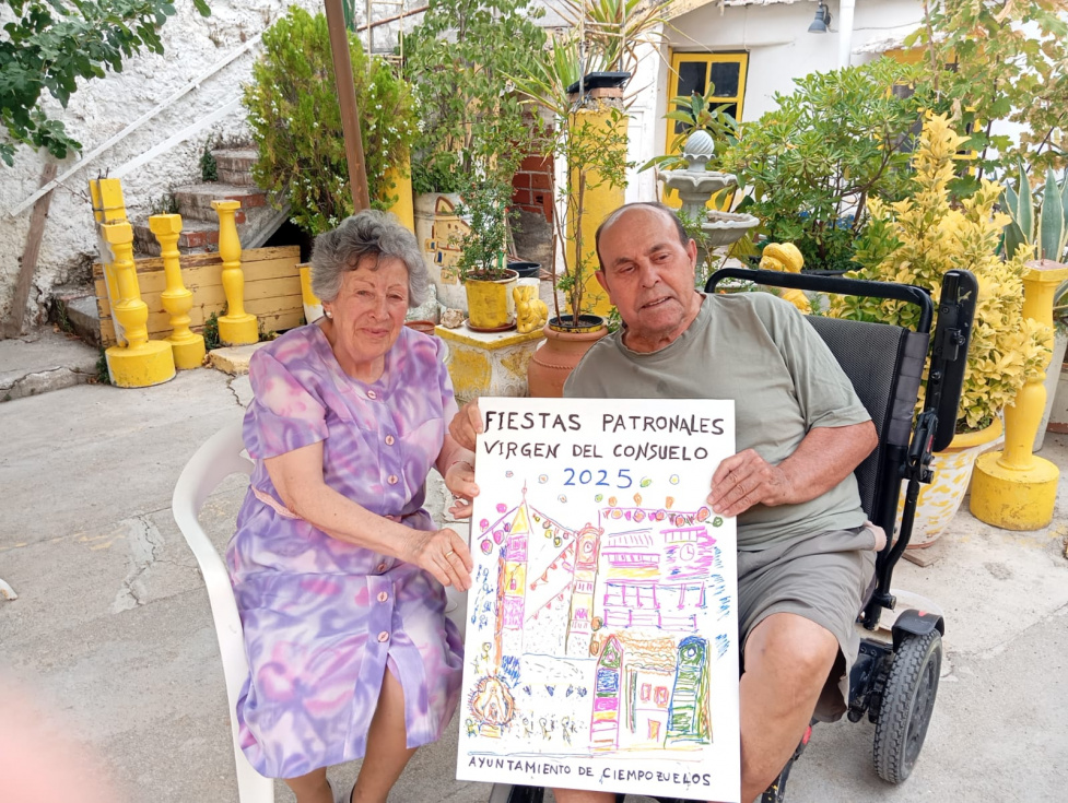 Balbino y su mujer, Nieves, posan con el cartel de las Fiestas de Ciempozuelos 2025.