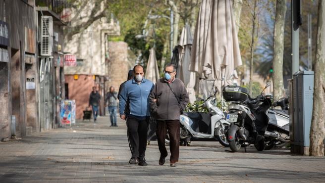 Dos hombres pasean agarrados del brazo.