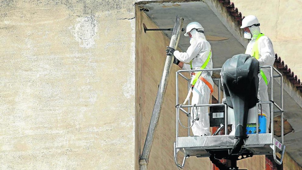 Imagen de archivo de 2014 de dos trabajadores retirando amianto. Foto: Heraldo de Aragón.