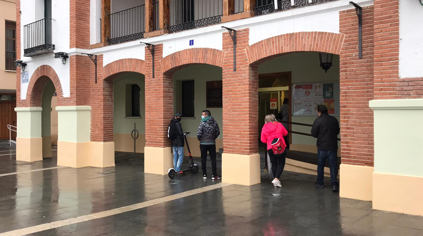 Vecinos de Pinto esperan su ticket para ser atendidos en las puertas del Ayuntamiento de Pinto.